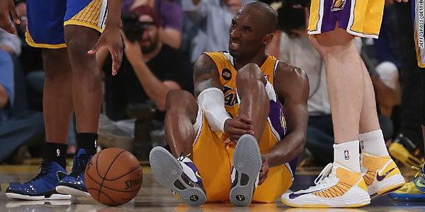 Kobe Bryant grabs the back of his left foot after going down to the ground. (ASSOCIATED PRESS)